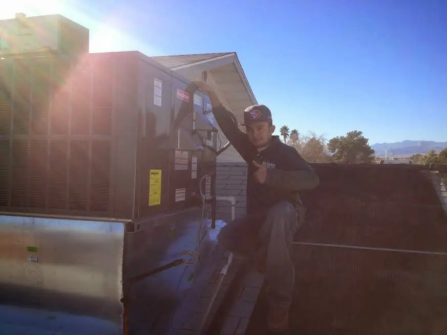 HVAC technician performing Air Duct Cleaning on a rooftop unit in Marrero